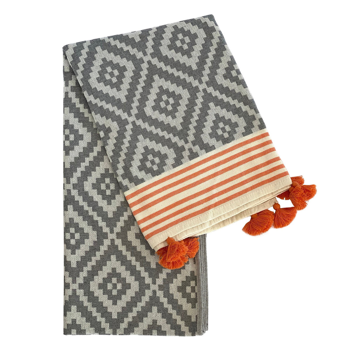 Folded gray Hilana Merida Turkish beach towel with diamond weave, orange-striped end, and orange tassels
