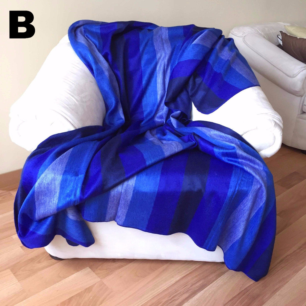 Blue and white striped alpaca bed blanket draped over a white chair