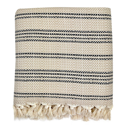 Folded beige and cream woven stripe Turkish throw with cream tassels