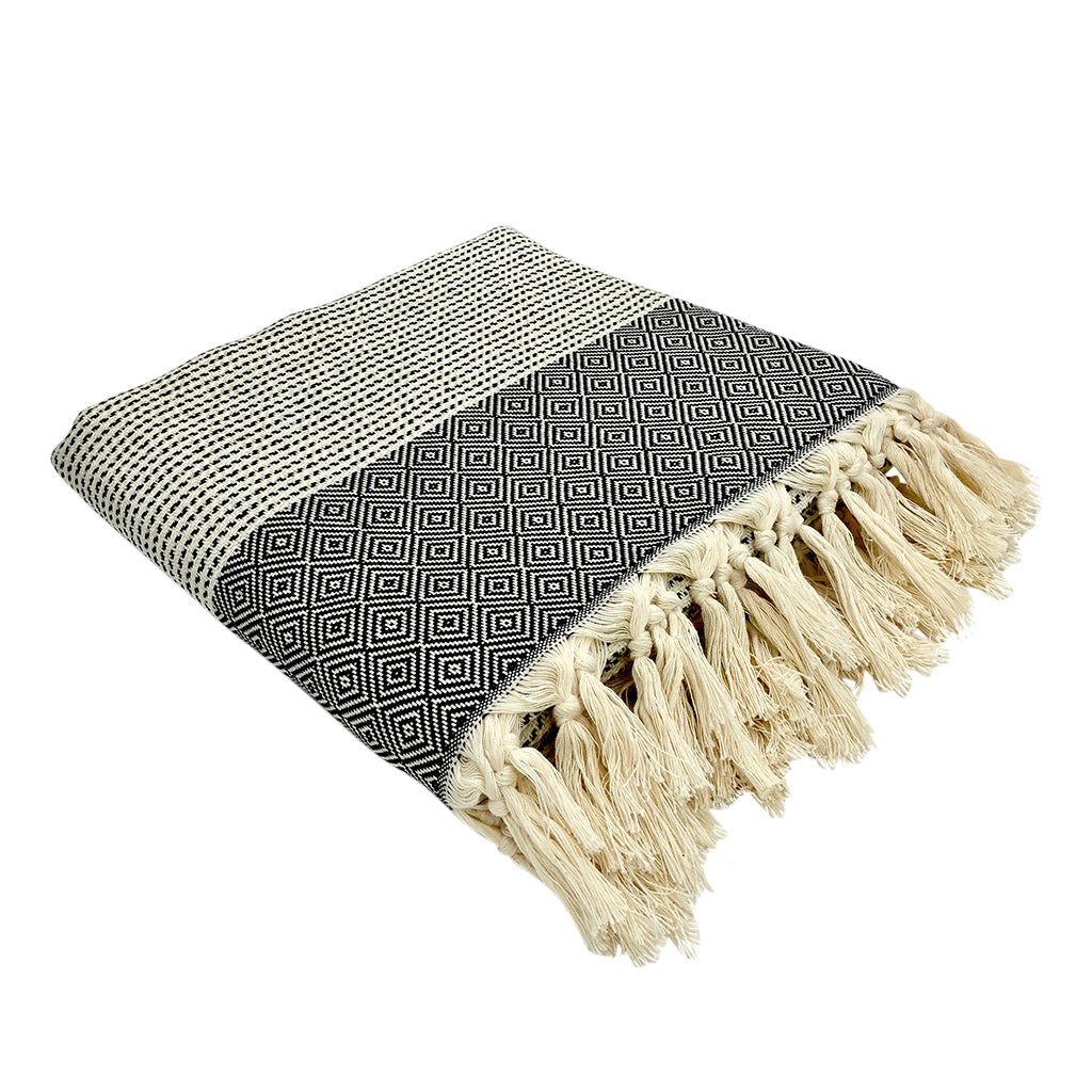 Folded black and white diamond stripe Turkish throw with thick cream tassel fringe