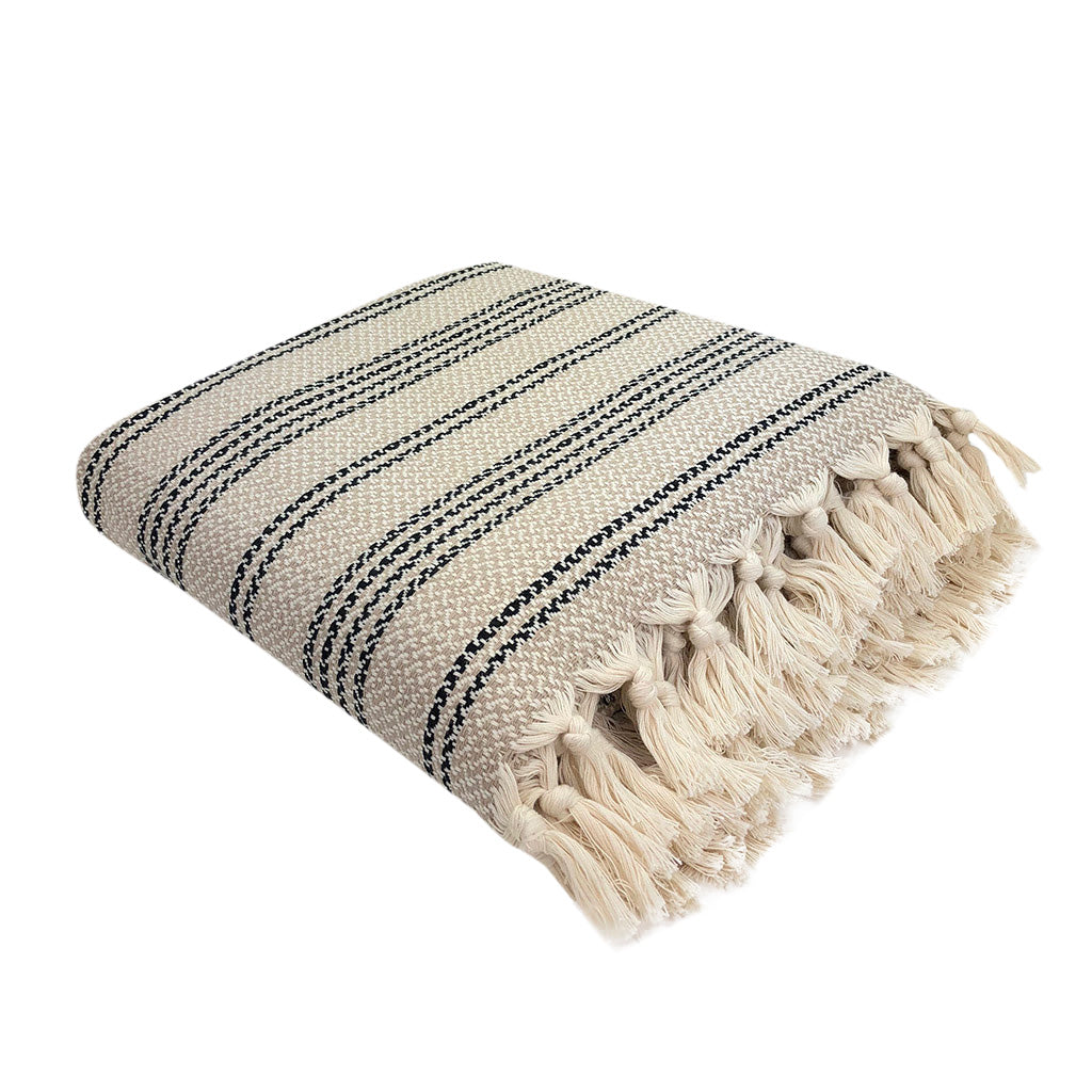Folded cream Turkish throw with fine gray and black stripes and woven tassels