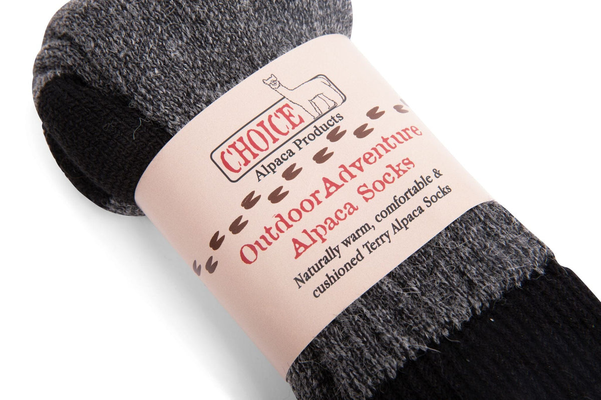 Closeup of dark gray OutdoorAdventure alpaca socks in their Choice Alpaca Products paper band
