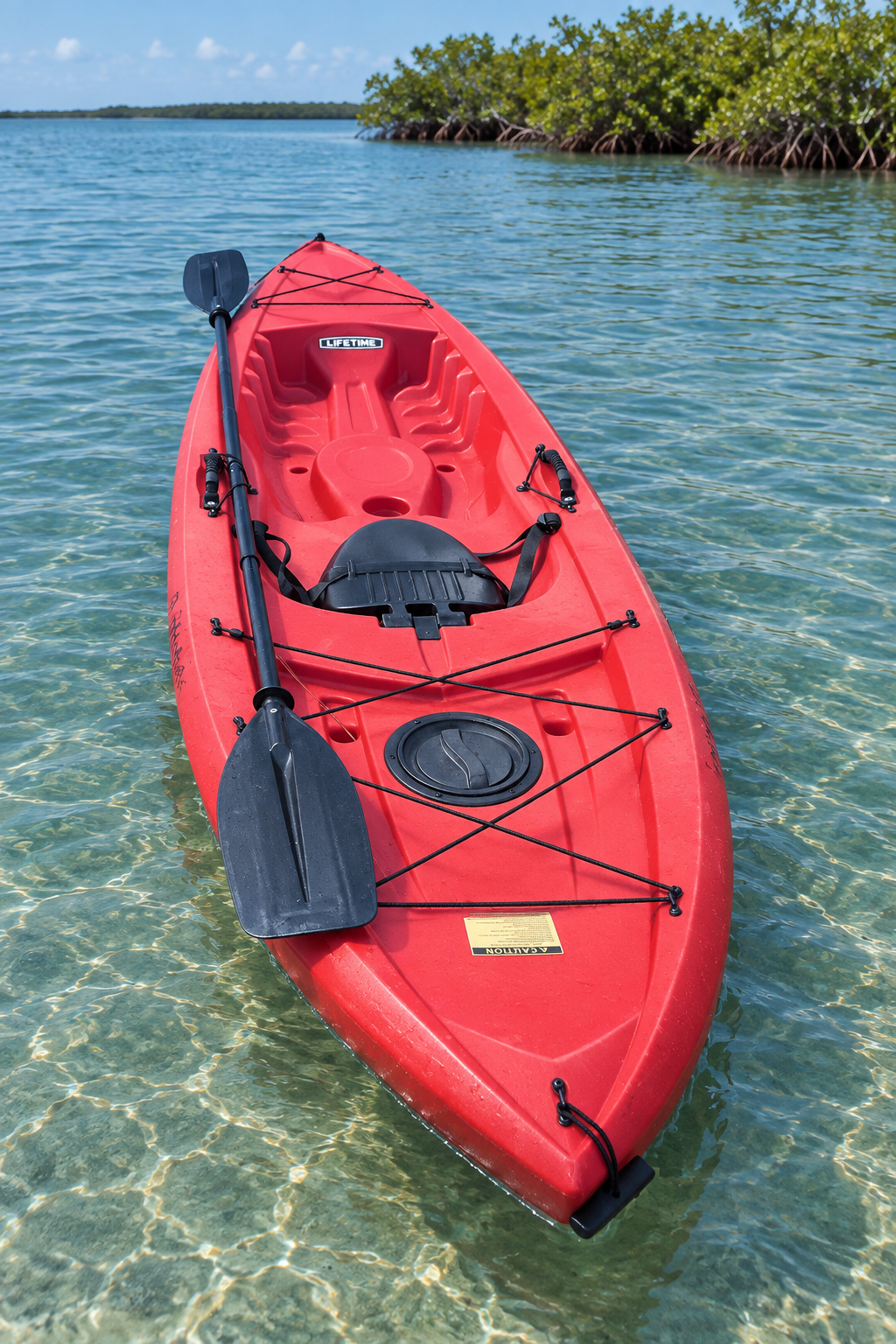 Red kayak floating on calm coastal water