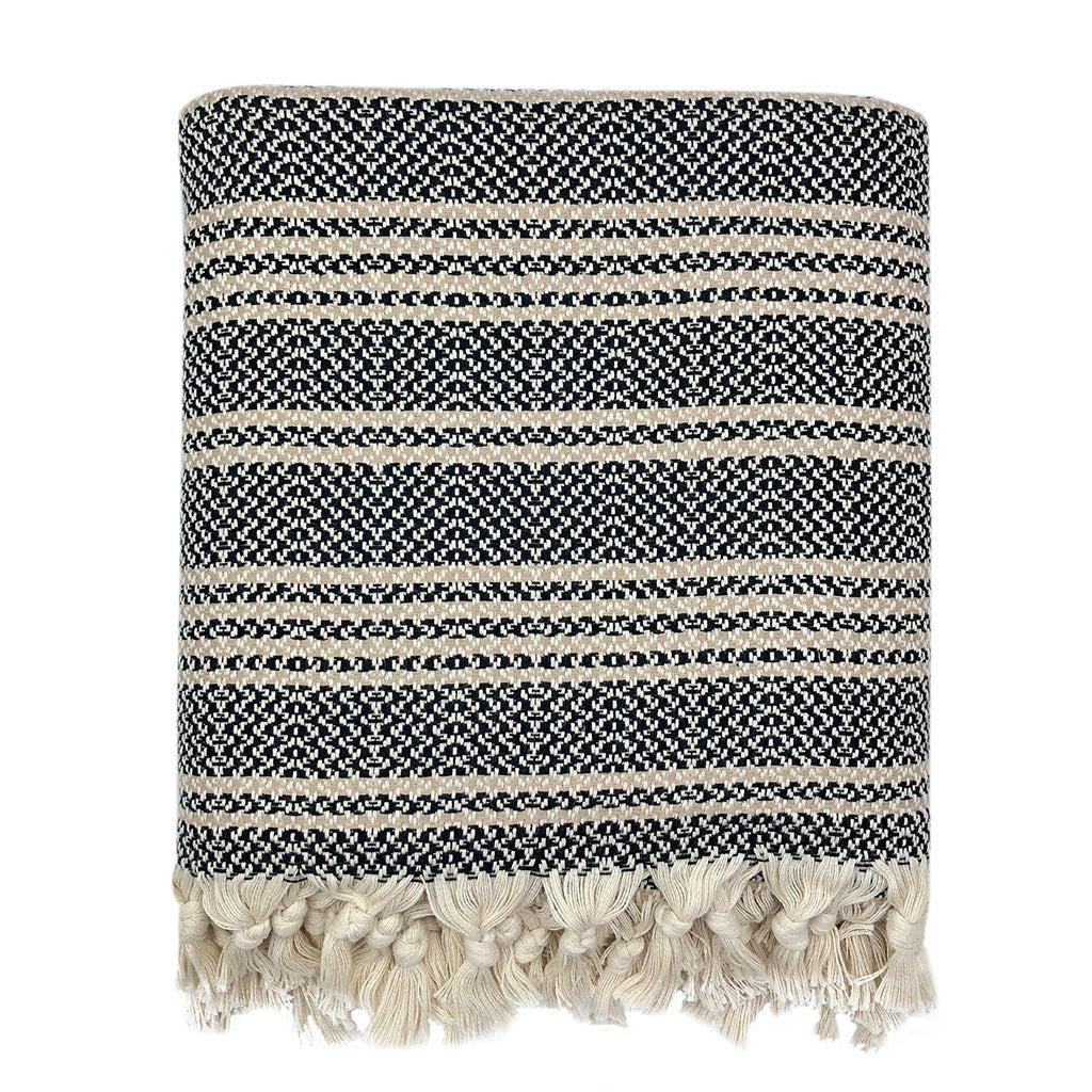 Folded black and cream woven stripe Turkish throw with knotted cream tassels