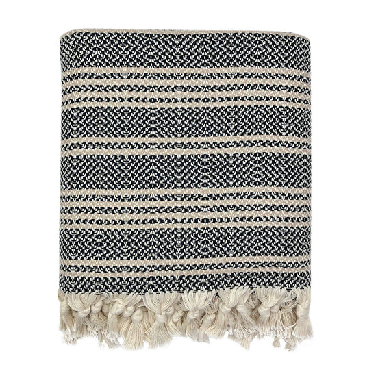 Folded black and cream woven stripe Turkish throw with knotted cream tassels