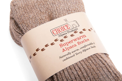 Closeup of brown Superwarm alpaca socks in their Choice Alpaca Products paper band