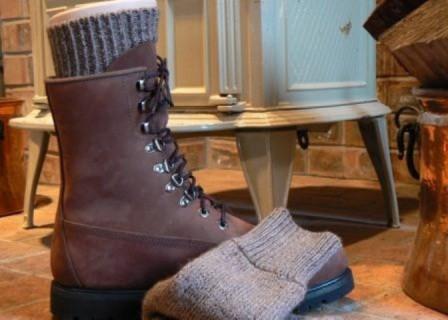 Brown hiking boot with a gray Superwarm alpaca sock cuff and a folded Superwarm sock beside it