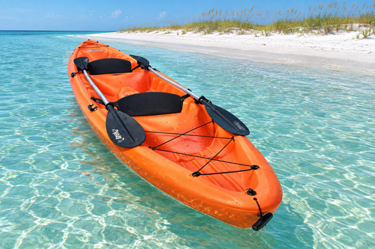 Tandem kayak floating beside a sandy island shore