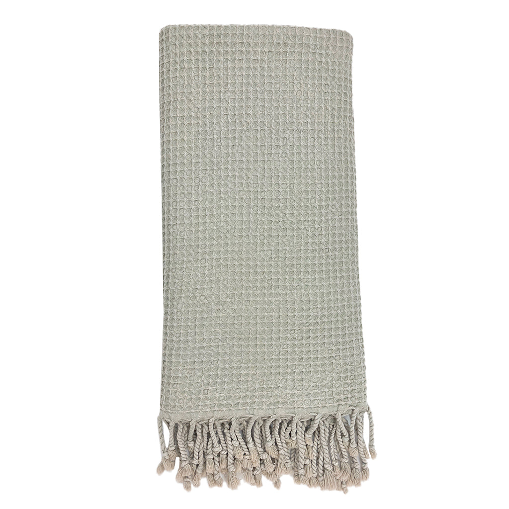 Folded light gray waffle weave Turkish towel with twisted fringe