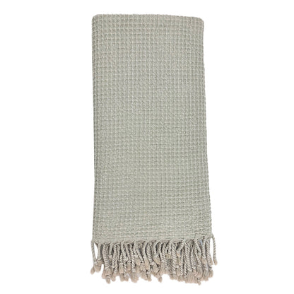 Folded light gray waffle weave Turkish towel with twisted fringe