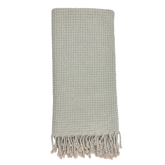 Folded light gray waffle weave Turkish towel with twisted fringe