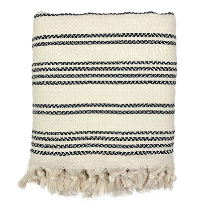 Folded cream woven stripe Turkish throw with fine black pinstripes and knotted fringe